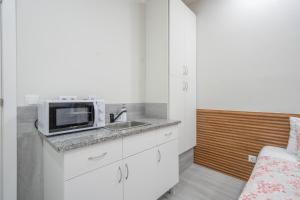 a kitchen with a sink and a microwave on a counter at Souto Centro Rooms in Braga +22 photos