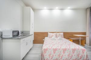 a small bedroom with a bed and a microwave at Souto Centro Rooms in Braga