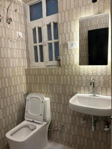 un baño con inodoro y lavabo en Joey's Homestay, en Rishīkesh 23 fotos más