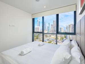 a bedroom with a white bed with a large window at Ruby Apartment Gold Coast in Gold Coast +111 photos