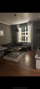 a living room with a couch and a table and a window at Superfin lägenhet 2 rok Söderfors wärdshus in Söderfors