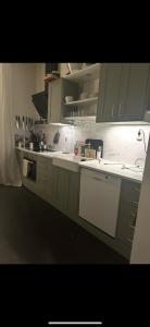 a kitchen with gray cabinets and white appliances at Superfin lägenhet 2 rok Söderfors wärdshus in Söderfors +10 photos