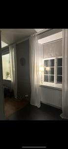 a room with a window and a white curtain at Superfin lägenhet 2 rok Söderfors wärdshus in Söderfors