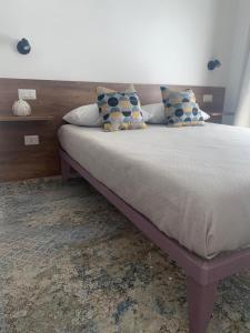 a bed with pillows on it in a bedroom at Dimora del Salento Apartment in Brindisi +10 photos