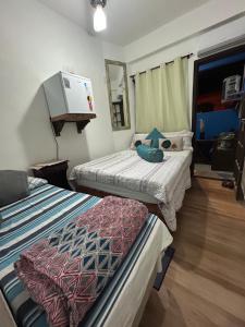 a bedroom with two beds and a mirror at Suíte de Lane e Mú 2 in Abraão