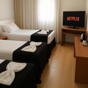 サルバドールにあるBahia Businees salvadorのベッド2台とテレビがあるホテルの部屋