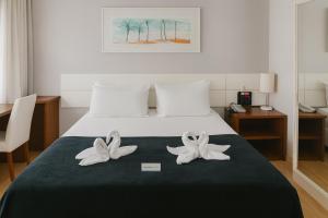 サルバドールにあるBahia Businees salvadorのベッドとタオルが2枚あるホテルの部屋