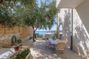 een patio met een tafel en stoelen en een boom bij Villa Eden Adults Only in Trogir