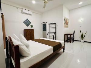 a bedroom with a bed and a table and chairs at Abheena - Weligama in Weligama
