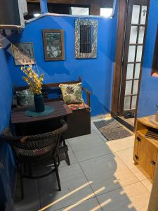 une salle à manger avec une table et un mur bleu dans l'établissement Suíte de Lane e Mú 2, à Abraão
