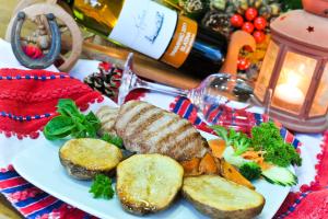 a plate of food with meat and vegetables on a table at Hotel Višnjica in Španat