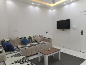 Dream House في الغردقة: غرفة معيشة مع أريكة وتلفزيون على الحائط