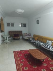 a living room with couches and a table and a rug at appartement Tozeur médina in Tozeur +1 photo