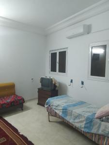 a bedroom with a bed and a tv in it at appartement Tozeur médina in Tozeur