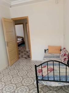 a bedroom with a bed and a room with a door at appartement Tozeur médina in Tozeur