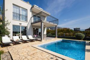 a house with a swimming pool and a balcony at Villa Fidelissima in Kaštela