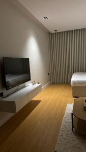 リヤドにあるHotel Studio in Hittinの壁に薄型テレビが取り付けられたリビングルーム