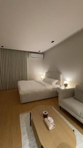 リヤドにあるHotel Studio in Hittinのベッドとソファとテーブルのある寝室