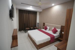 a hotel room with a bed and a television at The Holy Stay in Haridwār