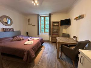 FerrassièresにあるChâteau Ferrassièresのベッドと机とテーブルのある寝室