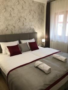 a large bed with two pillows on it in a bedroom at Babér Vendégház Tokaj in Tokaj