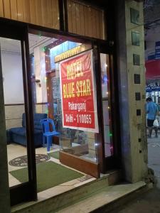 a blue star restaurant with a sign in the window at Hotel Blue Star - Paharganj Delhi in New Delhi