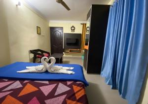 two white swans sitting on a bed in a room at Joys Stay in Trichūr