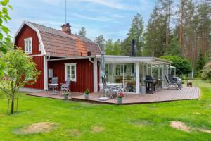a red barn with a deck and a patio at Lindgren Land in Ventzelholm
