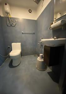 un baño con inodoro y lavabo en Joys Stay, en Trichūr