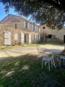 a table and chairs in front of a building at Studio cosy à la campagne in Montjustin