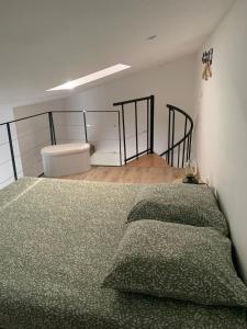 a bedroom with a bed with a green comforter at Studio cosy à la campagne in Montjustin +10 photos