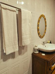 Covão do CoelhoにあるCasa Tertúliaのバスルーム(白いタオル、シンク、鏡付)