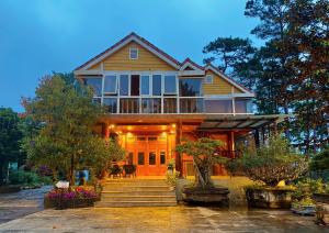 Kon PlongGià Làng Măng Đen Homestay的前面设有门廊和楼梯的大房子