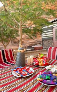 una mesa con platos de comida y un jarrón en ella en Serenity Camp, en Wadi Rum