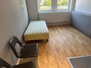 a chair and a bench in a room with a window at Apartment 17 in Sollentuna in Sollentuna +2 photos