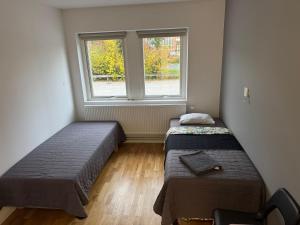 two beds in a room with a window at Apartment 17 in Sollentuna in Sollentuna