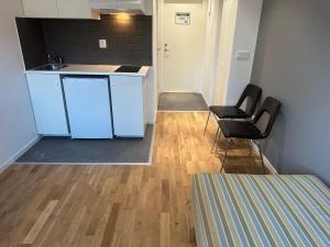 a kitchen with blue cabinets and two black chairs at Apartment 17 in Sollentuna in Sollentuna