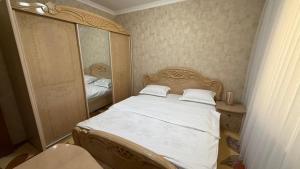 a small bedroom with a bed and a mirror at MOK Apartment in Samarkand