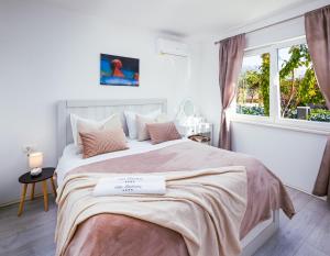 a white bedroom with a large bed with a window at Villa Fidelissima in Kaštela +51 photos
