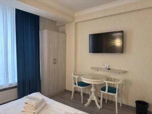 a hotel room with a bed and a table and chairs at Hotel Taht in Tashkent