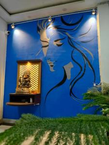 een blauwe muur met een muurschildering van een vrouw bij Capsule Hostel And PG Services in Gorakhpur +7 foto's