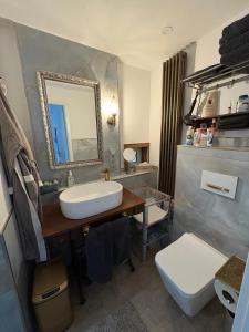 a bathroom with a sink and a toilet and a mirror at Alte Poststation in Quedlinburg