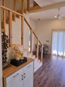 Una sala de estar con escaleras y un comedor. en Sky Bloom DLF 2BHK Luxury Villa Chattarpur, en Nueva Delhi