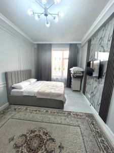 a bedroom with a bed and a stone wall at Keruen Saray Apartaments 1 in Türkistan +1 photo