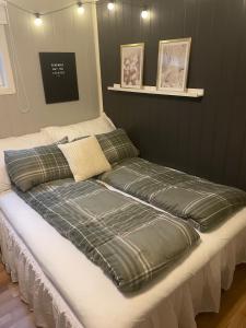 a bed with a green blanket on top of it at 1 roms kjellerleilighet Norheim, Haugesund in Karmøy