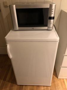 a microwave sitting on top of a refrigerator at 1 roms kjellerleilighet Norheim, Haugesund in Karmøy