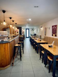 a restaurant with wooden tables and chairs and a counter at Hostal As Margaritas in Santiago de Compostela