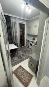 a small kitchen with a table and a dining room at Keruen Saray Apartaments 1 in Türkistan