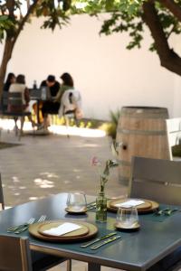a table with plates and glasses on top of it at Boutique Hotel Bodega CICLO ANDINO in Perdriel