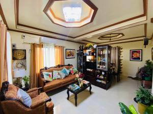 a living room with a couch and a table at Romar's Transient in Dalahian